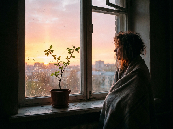 Een jonge vrouw kijkt naar een zonsopgang, symboliserend hoop en de eerste stapjes uit een depressie.