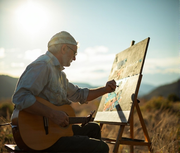 En man mitt i livet skapar konst utomhus, med naturen som ateljé, befriad från trånga rum, med en gitarr och färgpalett.