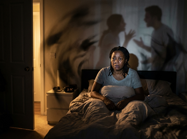 Picha inaonyesha mwanamke mwenye wasiwasi usiku, akiwa na mawazo yanayomsumbua na mwanga wa matumaini unaoashiria usaidizi wa kitaalamu.